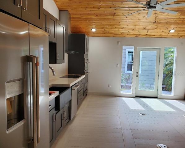 General Electric Cafe Appliances, including side by side refrigerator, dishwasher, cooktop, range hood, double oven (Oven and Adventium Oven). Tongue in groove ceiling.