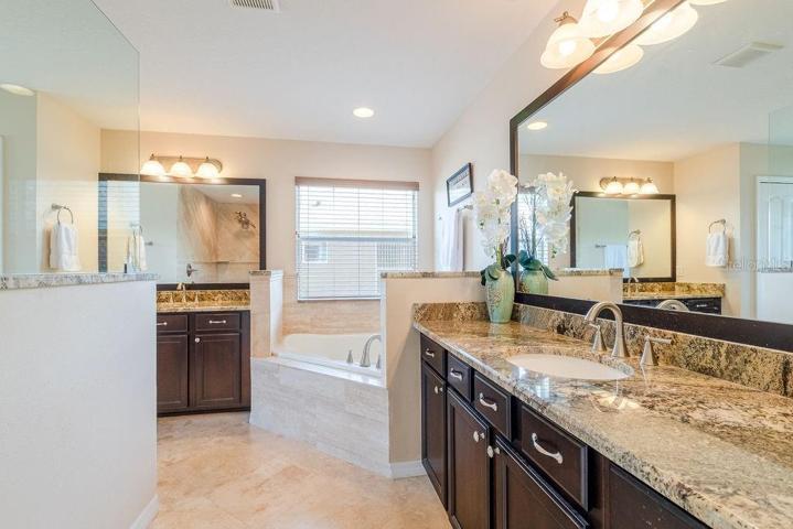 Completely remodeled main bathroom with granite countertops, travertine flooring, walk-in shower and large garden tub