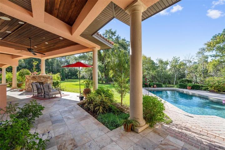 Part view of covered area near pool with outdoor kitchen, which leads to the wine tower, the casita, pool bath, storage and mother in law unit upstairs with wrap around balcony!