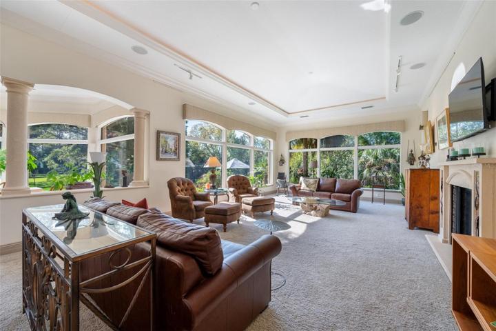 Part view of living area with gas fireplace right side, check out the amount of windows overlooking yard and pool!!