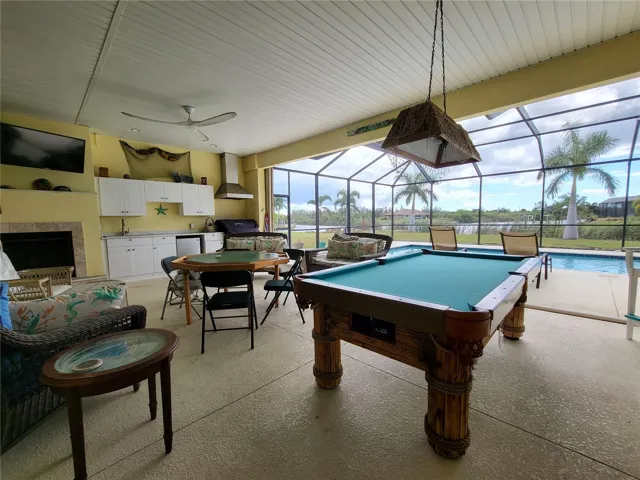 Outdoor lanai room great for entertaining or just relaxing after your swim.  Note the FIREPLACE with mounted TV above and the Outdoor Kitchen.