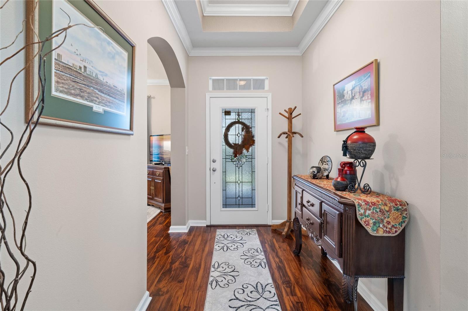 Foyer entryway w/ leaded glass door, tray ceiling, crown molding &amp; laminate flooring
