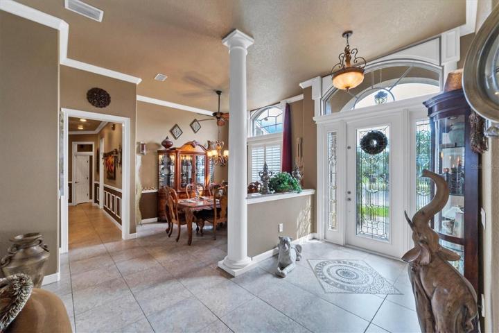 another view of foyer from living room area showing dining room and hall to guest rooms as well