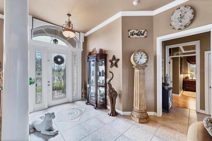 beautiful front door and foyer with medallion insert (door to far right is primary suite)