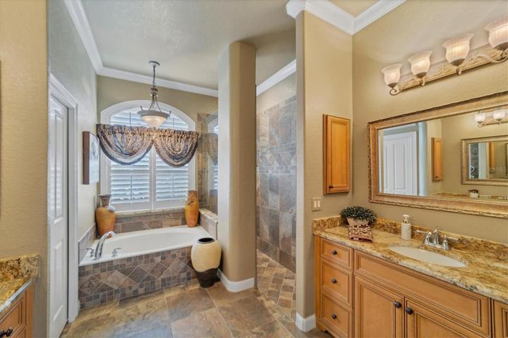 en suite showing garden tub, Roman walk in shower to right and pocket door on left to private water closet