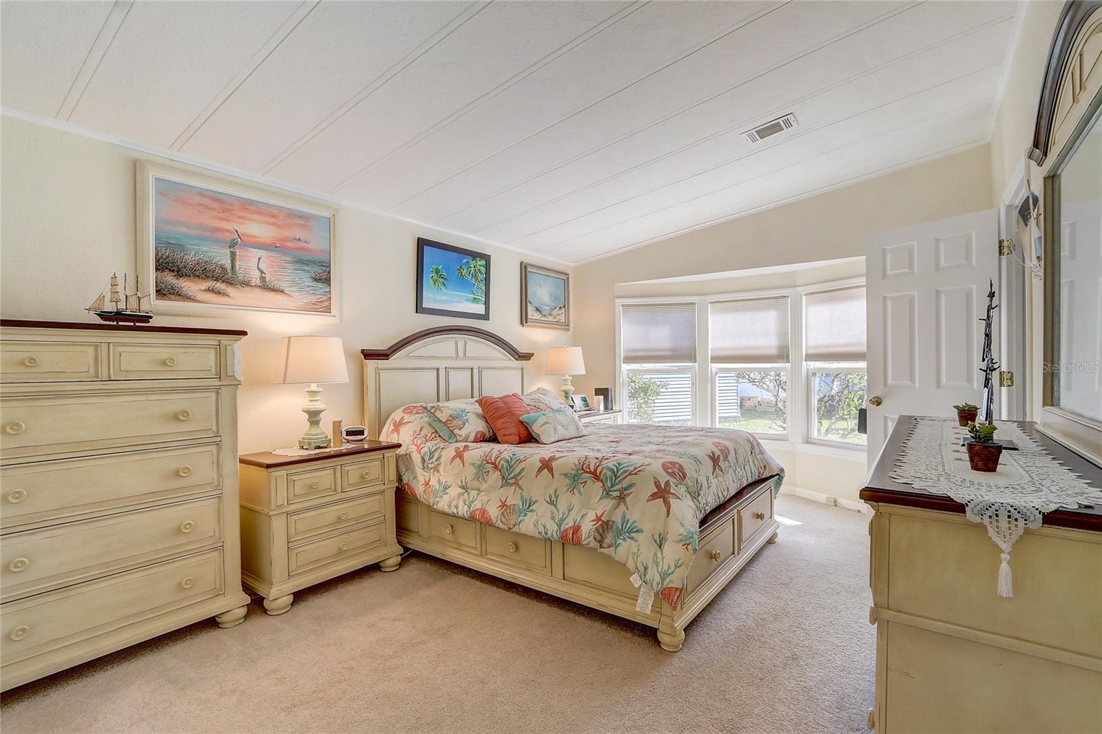 Massive primary bedroom with king size bed and views to backyard