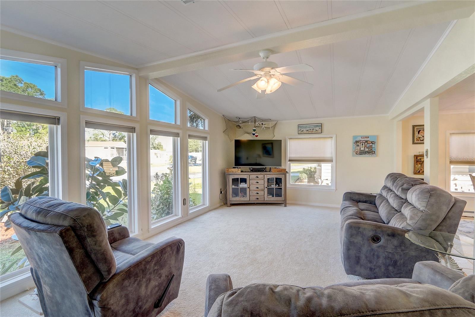 Living room is large with vaulted ceiling and panoramic outdoor views.