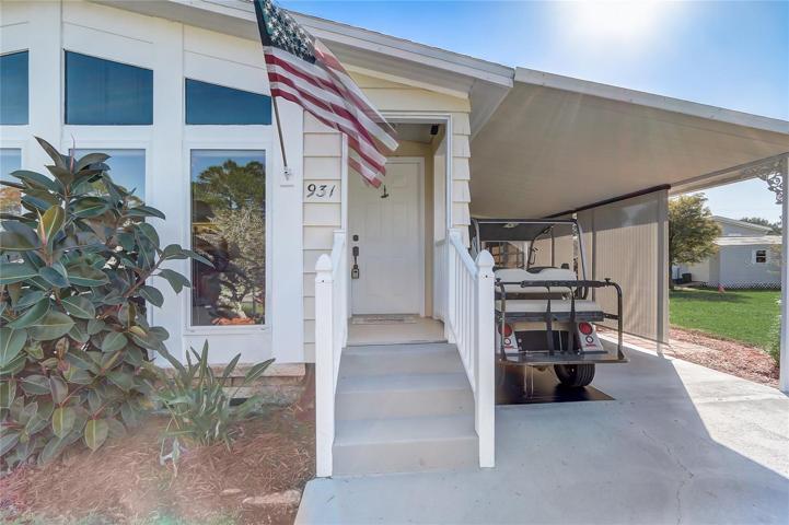 Covered entry with white vinyl handrails and steel entry door