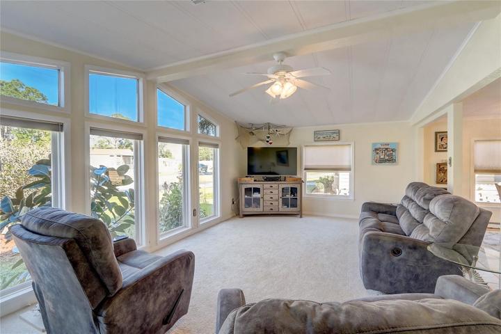 Living room is large with vaulted ceiling and panoramic outdoor views.
