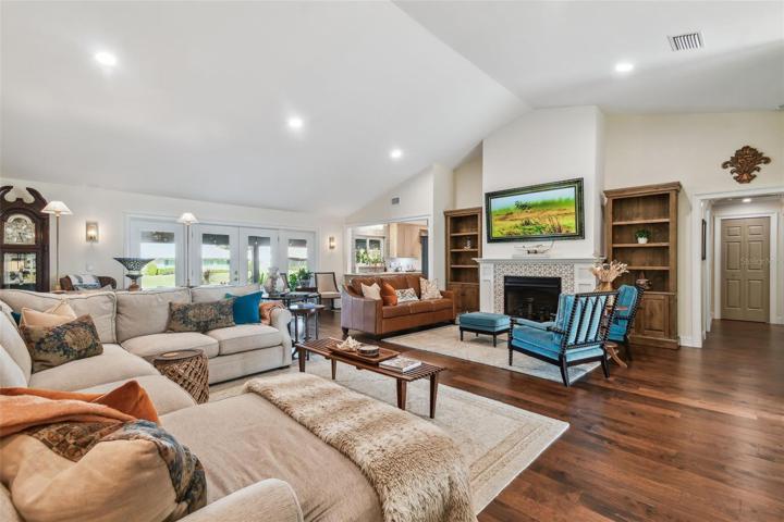 Cathedral vaulted ceiling with Lutron controlled LED lighting and propane remote controlled gas fireplace.  Engineered hardwood floors. Custom impact resistant French door to rear porch.