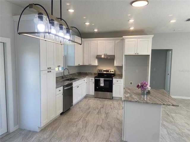Dining Area to Kitchen, Cabinets with crown molding, recessed lights, designer dining area light