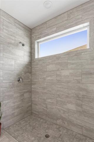 large step-in shower in primary suite. Additional transom window is an upgrade.