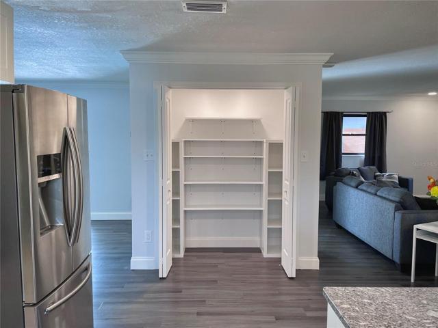 The kitchen pantry, as viewed from the kitchen with the main living room to the back right and second living room to the left