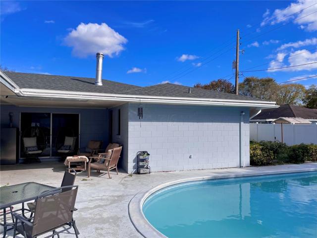 View of the pool and covered patio as seen from the outdoor BBQ
