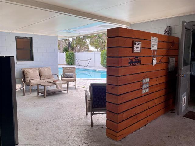 View of the patio and pool as seen from the front entry door of the home
