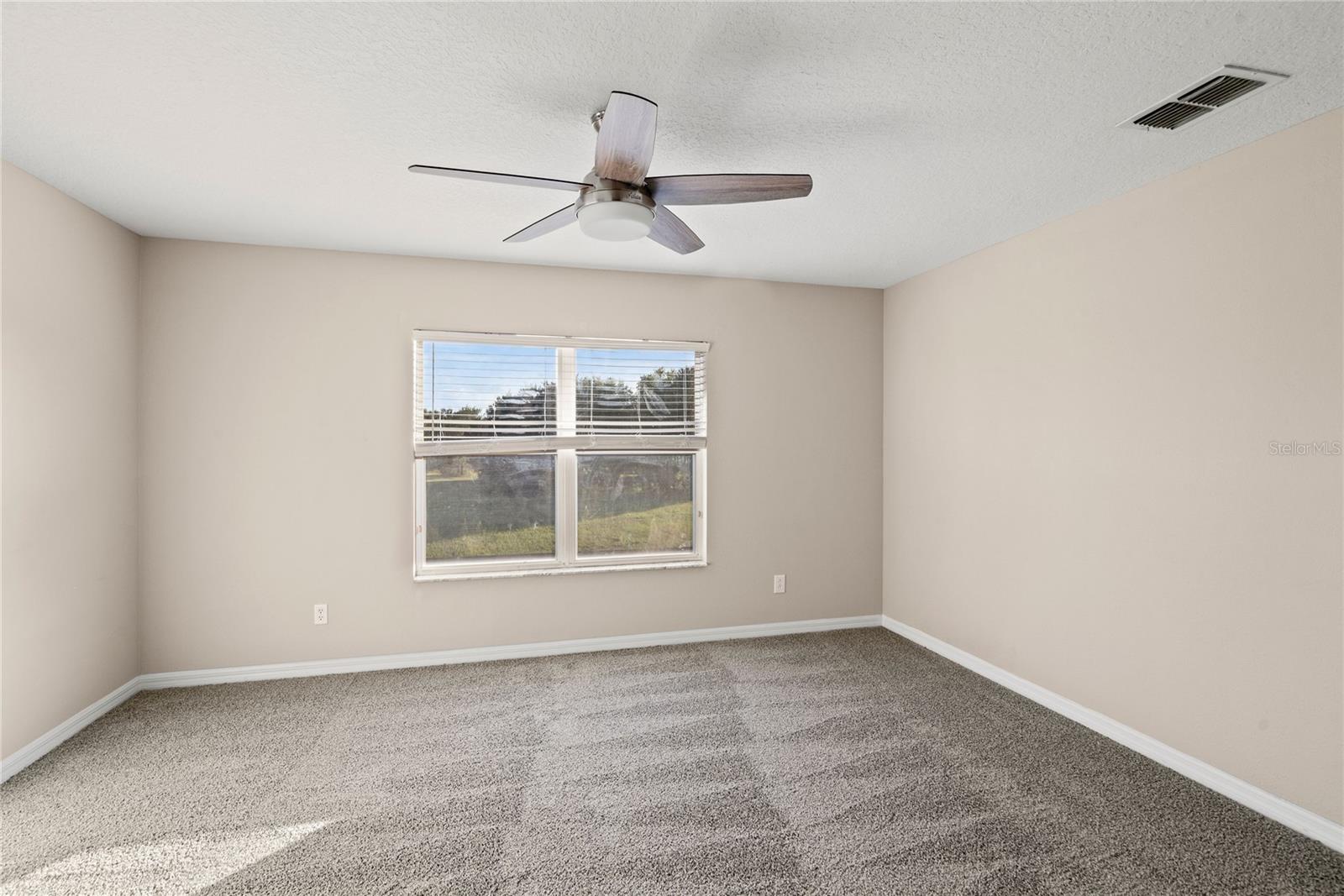 Master bedroom includes a walk-in closet, contemporary lighting and fresh carpeting