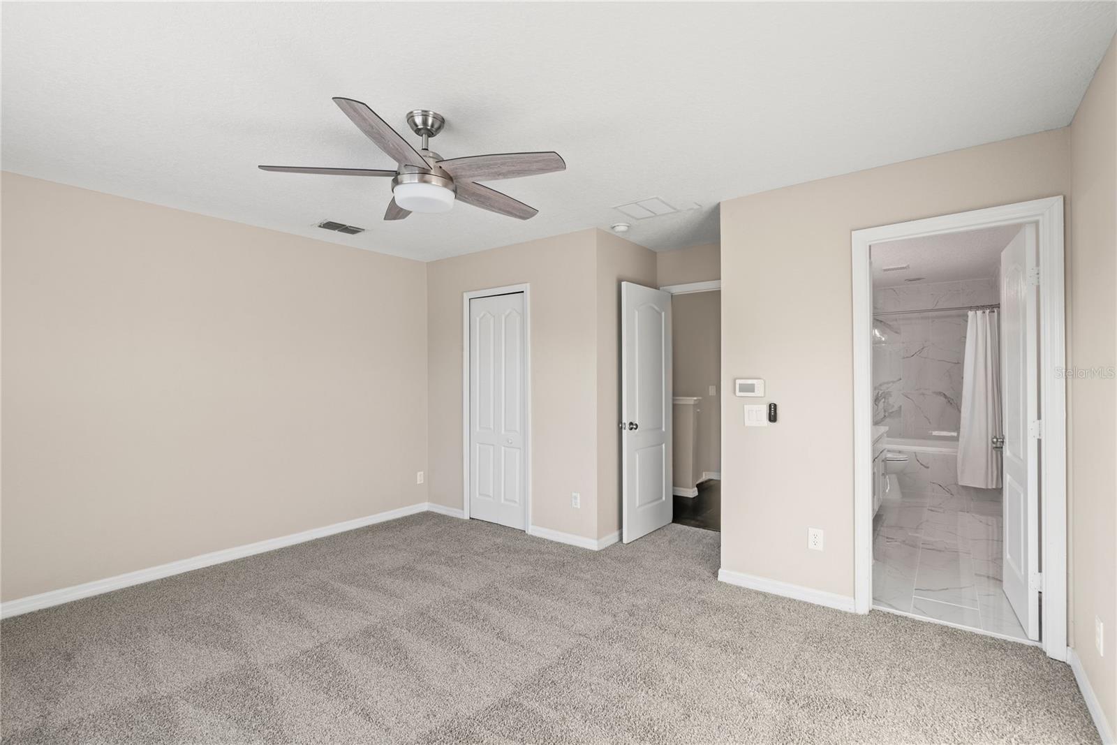 Master bedroom includes a walk-in closet, contemporary lighting and fresh carpeting
