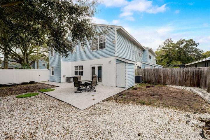 View of back of condominium with fenced back yard