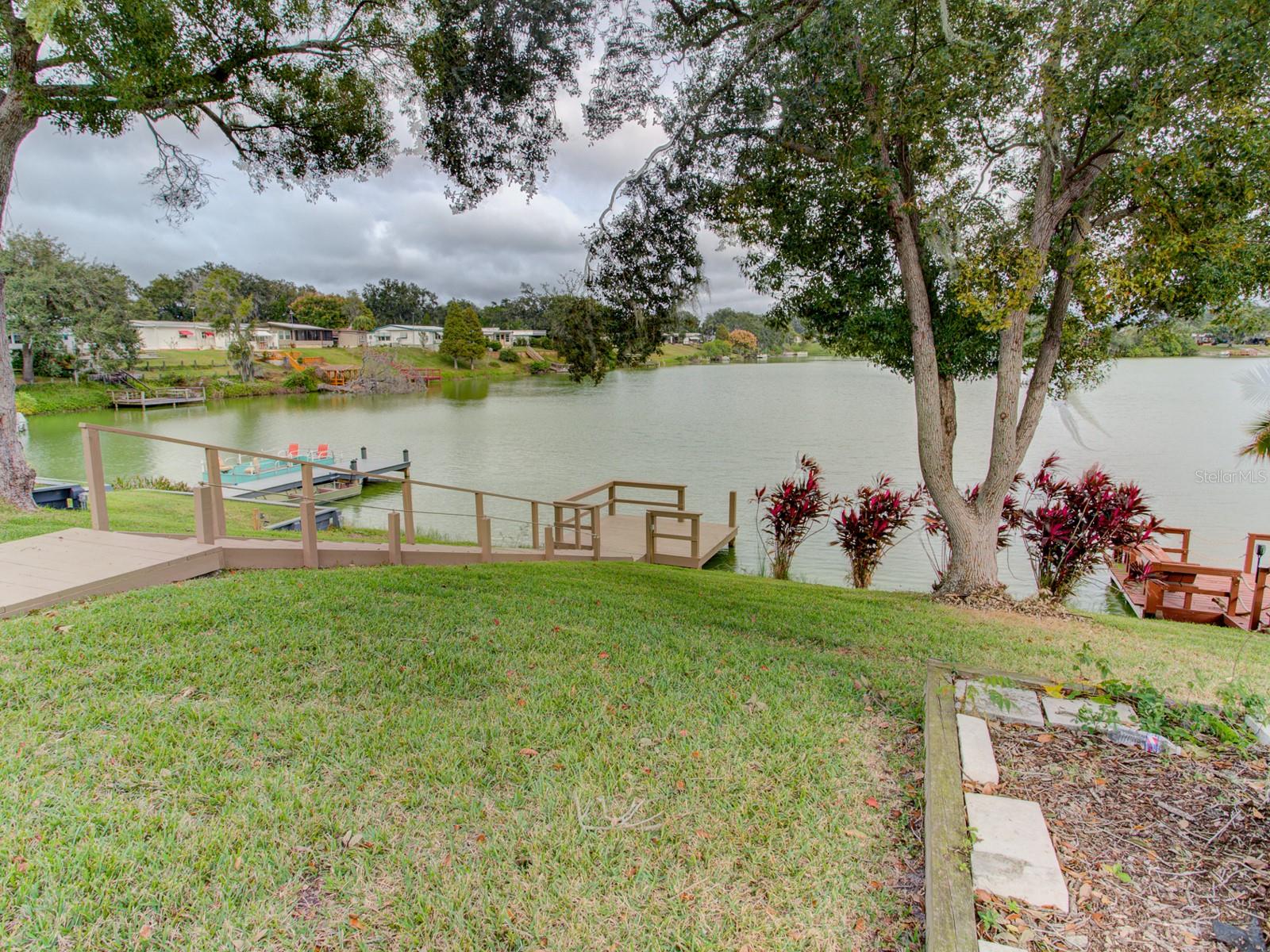 Backyard with a dock leading to the lake.