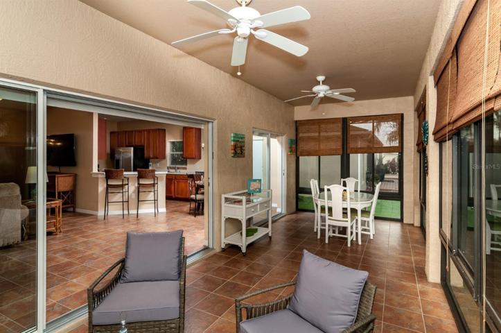 The covered and enclosed lanai has ceramic tile flooring and ceiling fans.