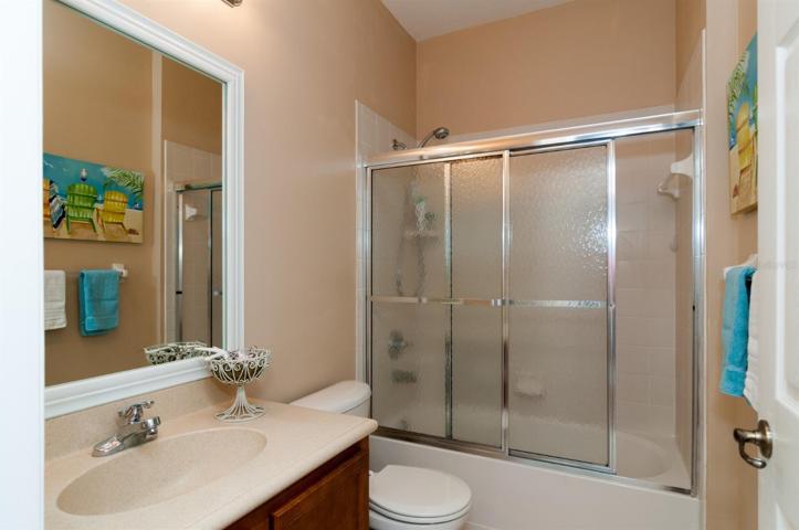 The guest bath has a combination shower and tub with a glass shower door. The molded sink is a plus.