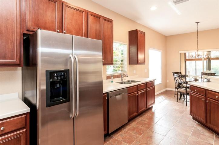 The kitchen has stainless steel appliances and ceramic tile flooring.