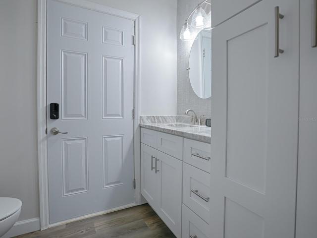 Bathroom featuring new custom White Shaker Cabinets, Granite Countertop, Paint & Wallpaper and Lighting Fixture.