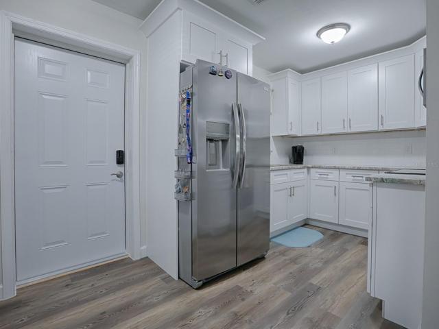 Completely updated Kitchen featuring 36" Shaker, Soft Close Cabinets with Crown Moulding, Granite Countertops, Stainless Appliances, Custom Subway Tile Backsplash and Luxury Vinyl Plank Flooring.