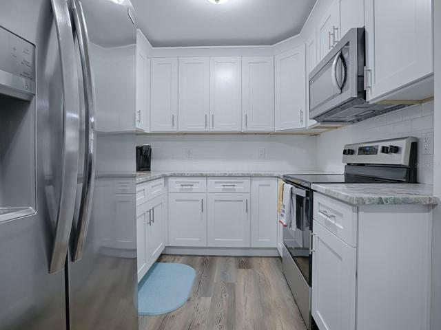 Completely updated Kitchen featuring 36" Shaker, Soft Close Cabinets with Crown Moulding, Granite Countertops, Stainless Appliances, Custom Subway Tile Backsplash and Luxury Vinyl Plank Flooring.