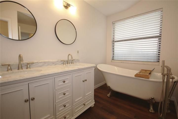 Large master bathroom with a claw foot tub and double sink vanity