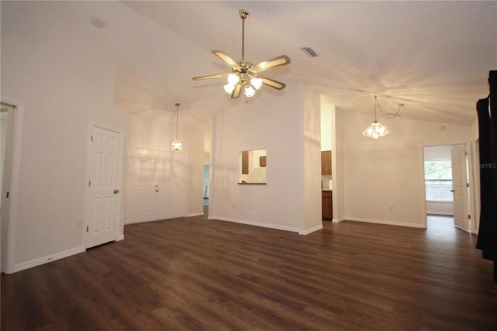 Another view of the living room with vaulted ceilings into the kitchen