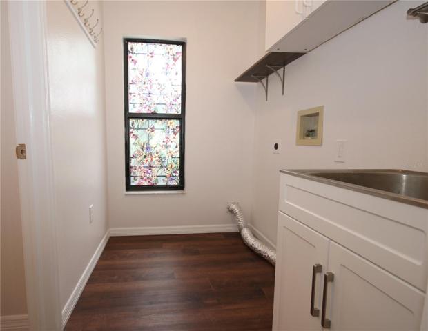 Inside laundry room with utility sink and stained glass window.