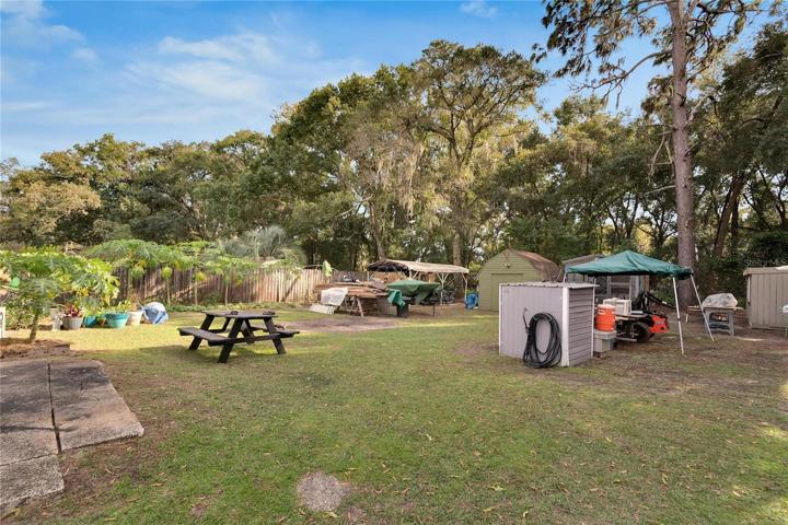 Backyard/small grey building is pump house for well