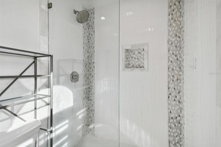 Tiled glass enclosed walk in shower.