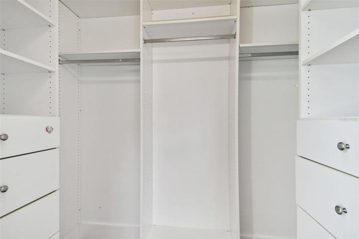 Walk in closet with custom storage.