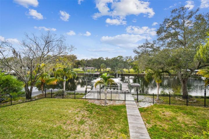 Fenced in yard with private doc with boat lift.