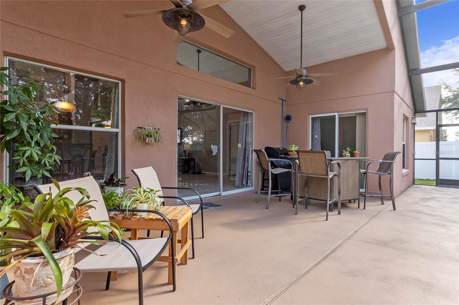 Screened pool area with roof covered sitting area.