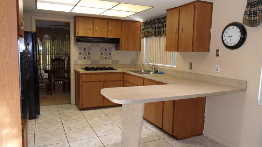 Kitchen has a breakfast bar as well as space for a kitchen table and easy access to the dining room.