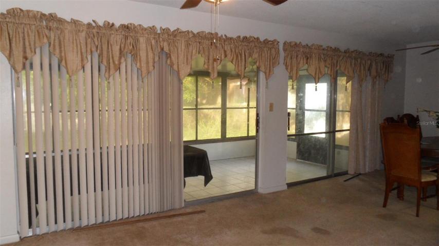Combination living/dining room, each with their own set of sliding glass doors leading to the enclosed patio