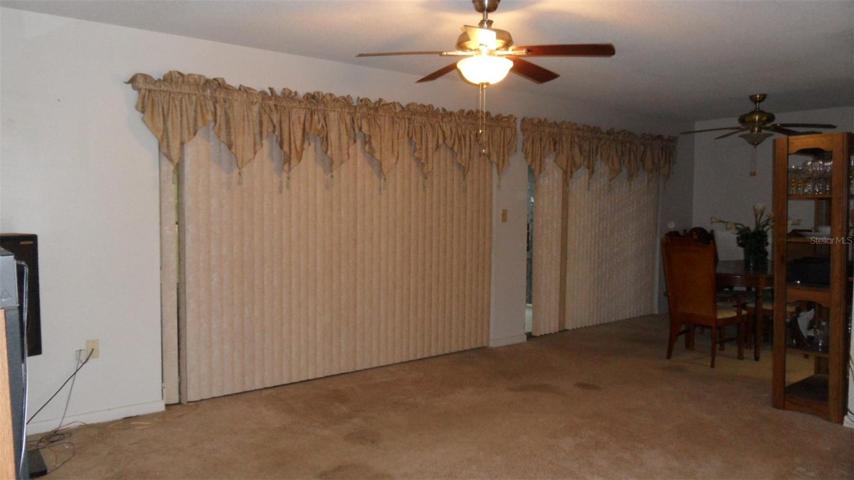Living room with 8' sliding glass doors and Dining room with 6' sliding glass doors and both with individual ceiling fan/lights