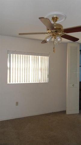3rd bedroom with window to front of home and ceiling fan/light and closet