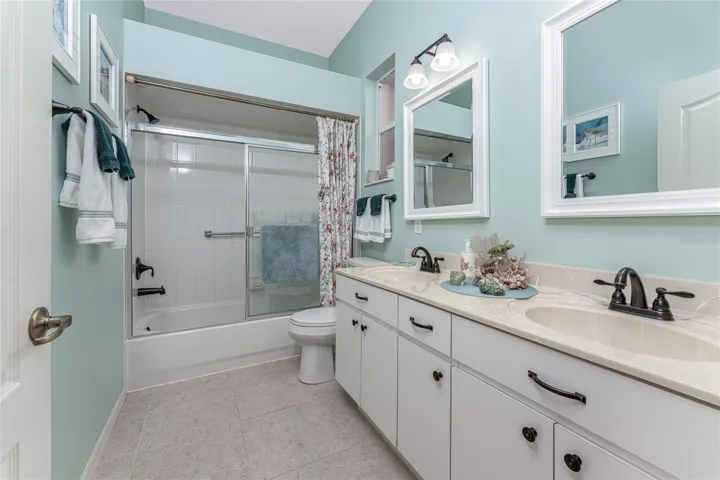 Guest bathroom features a vanity with updated hardware and new Kohler oil rubbed bronze fixtures.