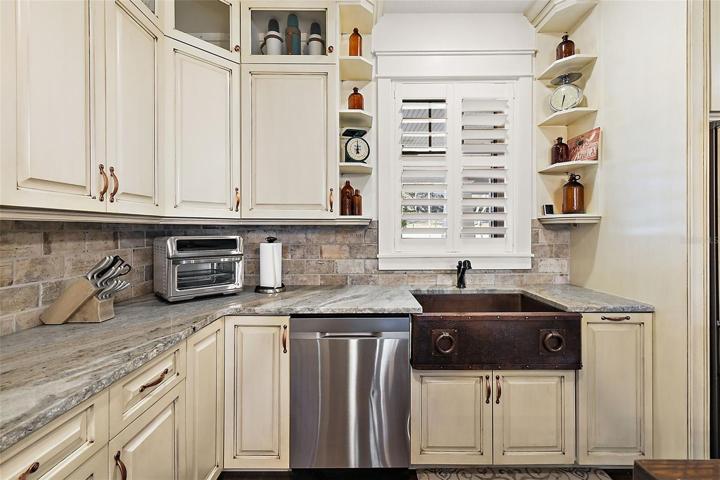 Chiseled edge granite tops and copper apron sink.