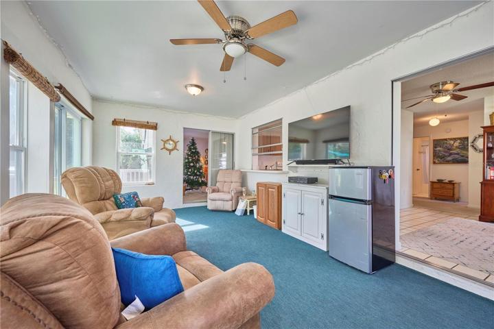 Florida room with views into dining/kitchen area and living room.