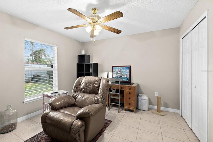 bedroom 2 with ceiling fan, tile floors