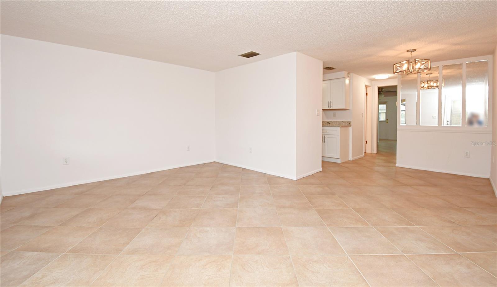 As you step inside, you will be greeted by beautifully updated living space adorned with modern LED light fixtures and stunning tile flooring throughout.