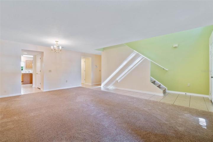 View from corner of living/dining room combo toward kitchen and stairs.