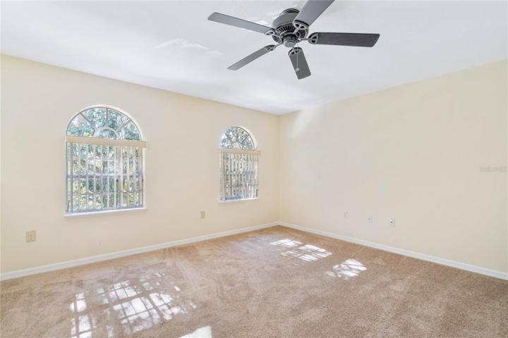 Second floor loft area with ceiling fan.