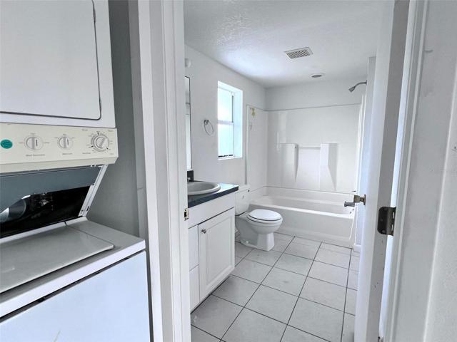 Laundry closet and full bathroom across hall from bedroom on first floor