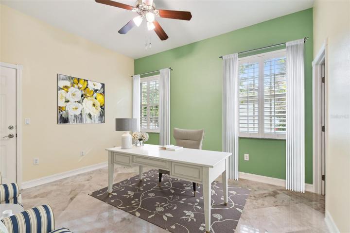 Bedroom / office with garage entry, digitally staged.